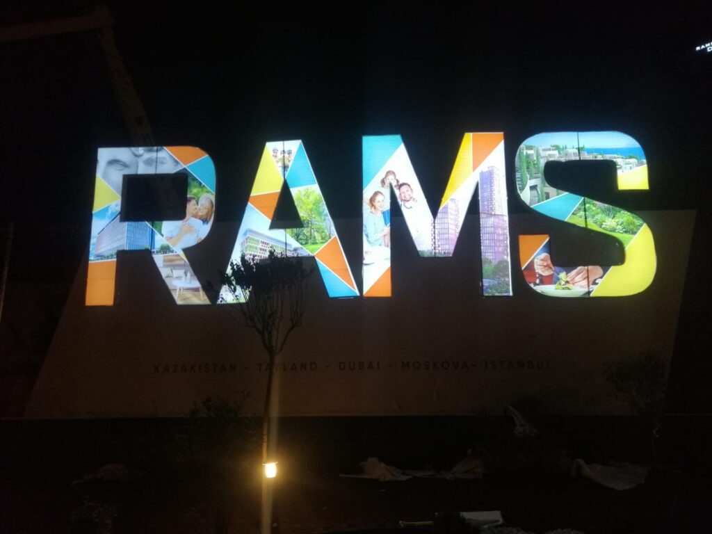 Rams inşaat çatı tabelası ışıklı gece görüntüsü.